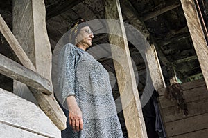 Portrait of a Muslim woman standing in wooden hut portico