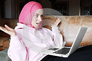 Portrait of a muslim woman working with computer and wearing a head scarf. Isolated.