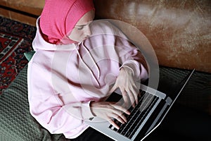 Portrait of a muslim woman working with computer wearing a head scarf. Isolated.