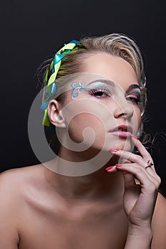 Portrait of naked blonde model girl with creative makeup, bright colorful eyeshadows and pink lipstick, isolated at the