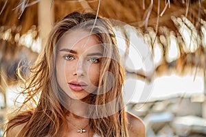 Portrait of natural blonde woman with freckles and long hair. Girl looking at the camera