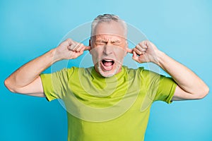 Portrait of negative unsatisfied person closed eyes fingers in ears open mouth isolated on blue color background