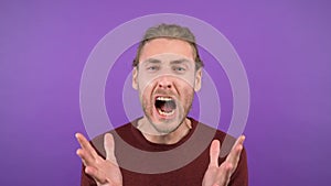 portrait of a nervous screaming man on isolated purple background. 4K