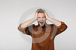 Portrait of nervous young man with headache grabbing her head