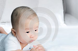 Portrait of a newborn Asian baby boy on the bed , Charming Fat baby 5 month old lies in bed looking with copy space,,soft and