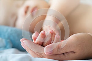 Portrait of newborn Asian baby boy sleep on the bed , cute selective hand foot feet fingers