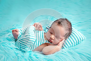 Portrait of a newborn baby 0-14 days old on a blue fur background, a newborn`s dream