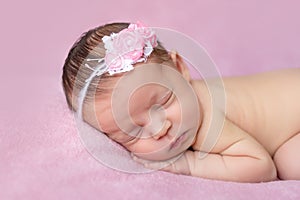 Portrait of a newborn baby girl sleeping on a pink blanket background, place for text, healthy baby sleep