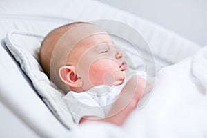 Portrait of newborn baby sleeping in bouncer chair