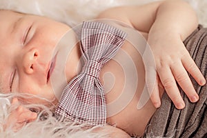 A portrait newborn lies on a fur blanket, cute, sleeping, tiny baby. Mom and her baby. Maternity. Beautiful conceptual image