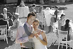 Portrait of newly wedded couple with champagne glasses at wedding reception