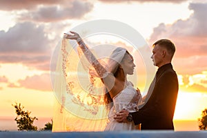 Portrait of newlyweds in the rays of the setting sun