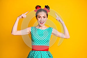 Portrait of nice amazed cheery girl wearing teal dotted dress showing new hairdo isolated over vibrant yellow color