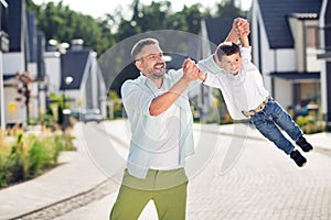 Portrait of nice attractive cheerful adorable friends daddy carrying son having fun outside sunny day weekend pastime