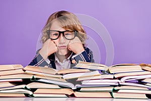 Portrait of nice bored schoolboy reading pile book science  over purple violet color background