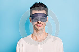 Portrait of nice calm brunet guy wearing sleep mask drowsing sleeping  over bright blue color background