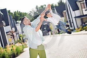 Portrait of nice cheerful adorable friends daddy carrying son having fun holiday daydream playing outside residence