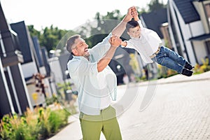 Portrait of nice cheerful careful adorable best friends daddy carrying son having fun playing outside sunny day cottage
