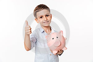 Portrait of a nice cute little kid holding piggy bank
