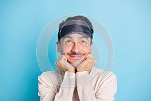 Portrait of nice funny cheery minded brunet guy wearing sleep mask looking up fantasizing isolated over bright blue