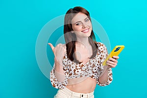 Portrait of nice girlfriend seductive summer top recommend ebay store online point finger website phone isolated on cyan