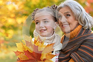 Portrait of nice grandmother of granddaughter in autumn