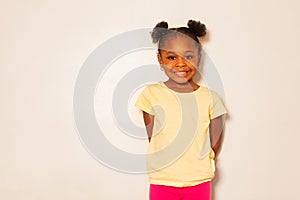 Portrait of nice little black girl smile over wall
