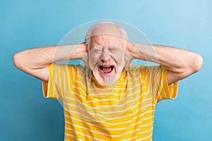 Portrait of nice outraged evil gray-haired man screaming closing ears isolated over bright blue color background