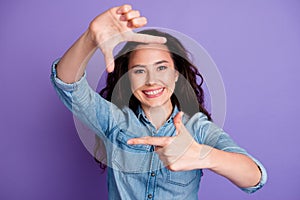 Portrait of nice positive lady beaming smile arms fingers demonstrate cadre gesture isolated on purple color background
