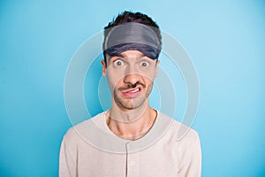 Portrait of nice puzzled brunet guy wearing sleep mask cant asleep dislike isolated over bright blue color background