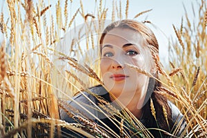 Portrait of woman on a field full of yellow ears