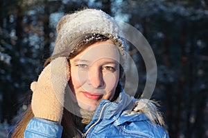 Portrait of the nice young woman in the blue jacket and a cap