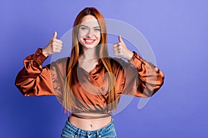 Portrait of nice young woman show thumb up empty space wear brown shirt  on purple color background