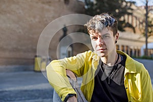 Portrait of a non binary person looking at camera while posing outdoors.