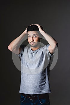 Portrait of a normal boy over grey background . Attractive young man