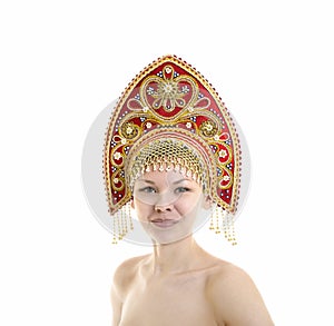 Portrait of Nude smiling girl in a kokoshnik headdress on a white background.