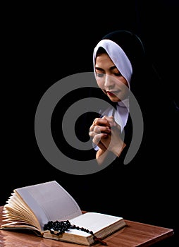 Portrait of nun praying and reading scripture