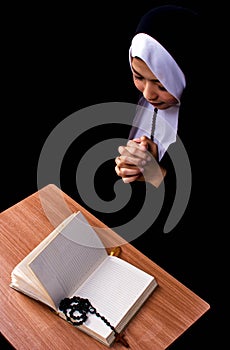 Portrait of nun praying and reading scripture