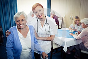 Portrait of a nurse assisting a senior using a walker