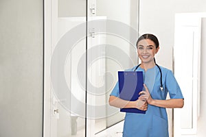 Portrait of nurse with clipboard in hallway. Medical assisting