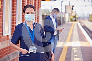 Portrait Of Nurse On Railway Platform Wearing PPE Face Mask Commuting To Work During Pandemic