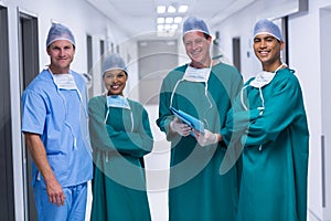 Portrait of nurse and surgeons standing in corridor