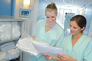 Portrait 2 nurses checking laundry list at hospital