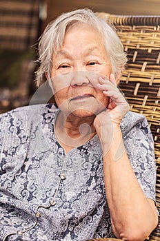 Portrait of a obaasan grandma seated, posing with the hand on