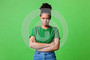 Portrait of offended black woman standing with folded arms