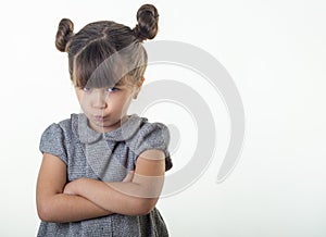 Portrait of offended and moody cute european kid with brunette hair frowning and pursing lips, looking from under forehead bothere