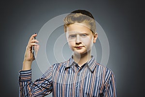 Portrait of offense boy with mobile or cell phone. Negative human emotion