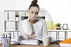 Portrait of an office employee reading a large book