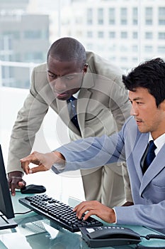 Portrait of an office worker showing something to his colleague