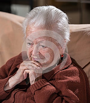 Portrait of old gray-haired sad woman